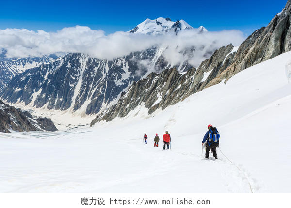 冬天正在雪山上行进的登山者励志努力坚持不懈